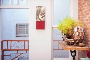 A room with a brick wall, a window, and a metal railing. - We Share Hostel (Tainan)