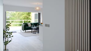 Een modern interieur met een groene bank, een eettafel en een potplant.