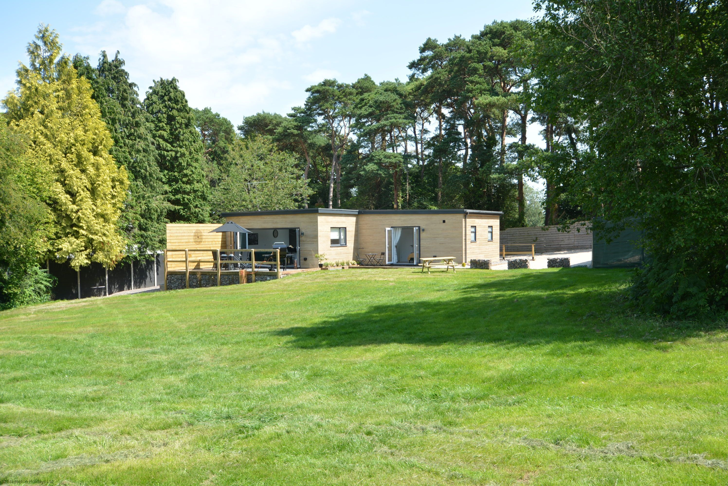 A single-story building with a flat roof, surrounded by a grassy area and trees.
