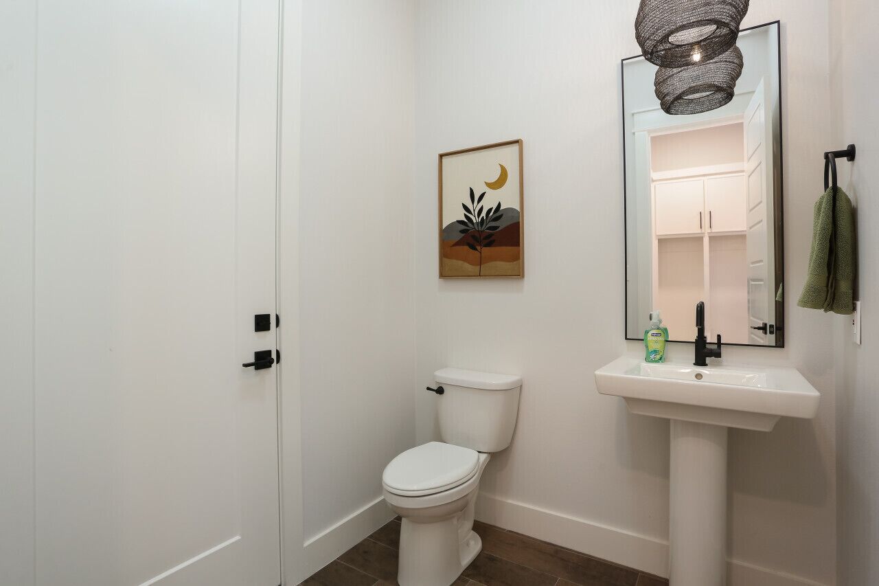 Een badkamer met een toilet, een wastafel en een spiegel.