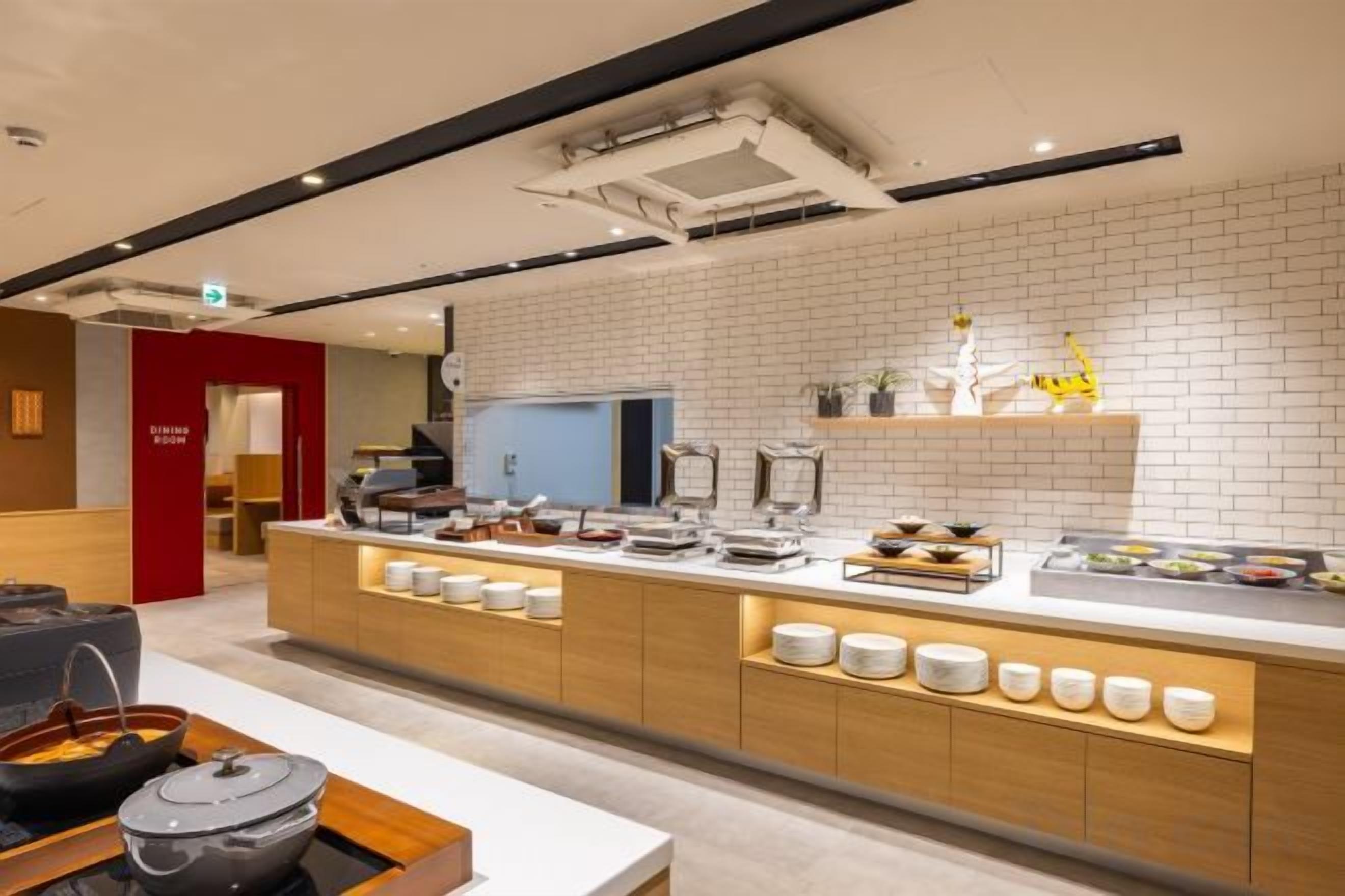 Cozinha moderna com ilha central, painel de azulejos brancos e diversos eletrodomésticos.