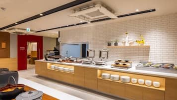 Cozinha moderna com ilha central, painel de azulejos brancos e diversos eletrodomésticos.