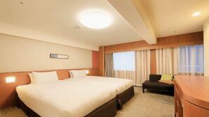 Une chambre d’hôtel avec un grand lit, un bureau et une chaise.