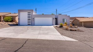 A modern two-story house with a garage, a driveway, and a landscaped front yard.