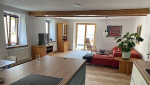 Una cocina moderna con estufa integrada, armarios de madera y un comedor con mesa y sillas.