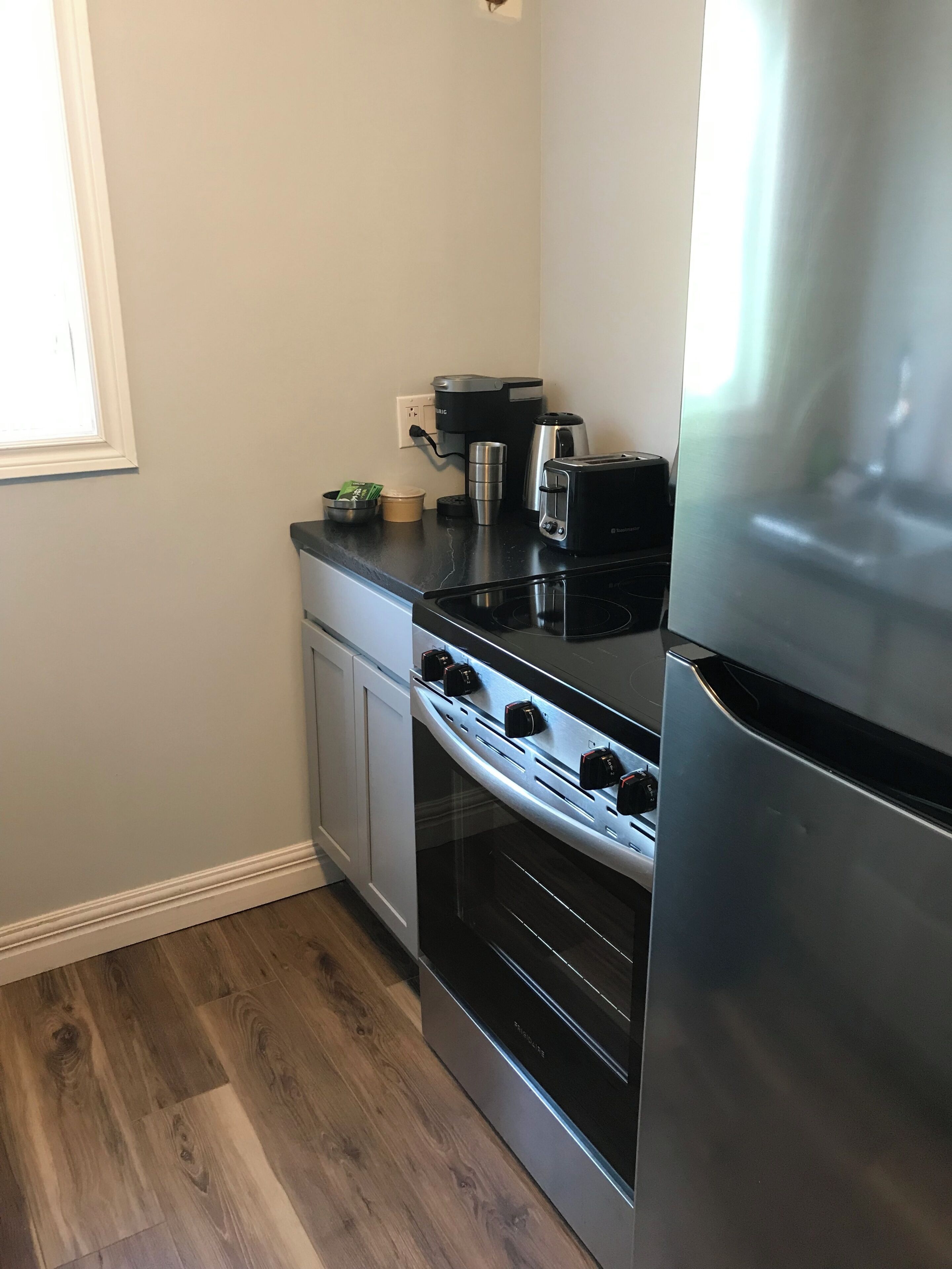A kitchen with a stove, oven, and refrigerator.