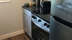 Una cocina con estufa, horno y refrigerador.