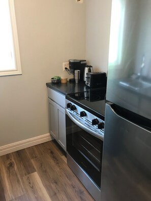 Una cocina con estufa, horno y refrigerador.