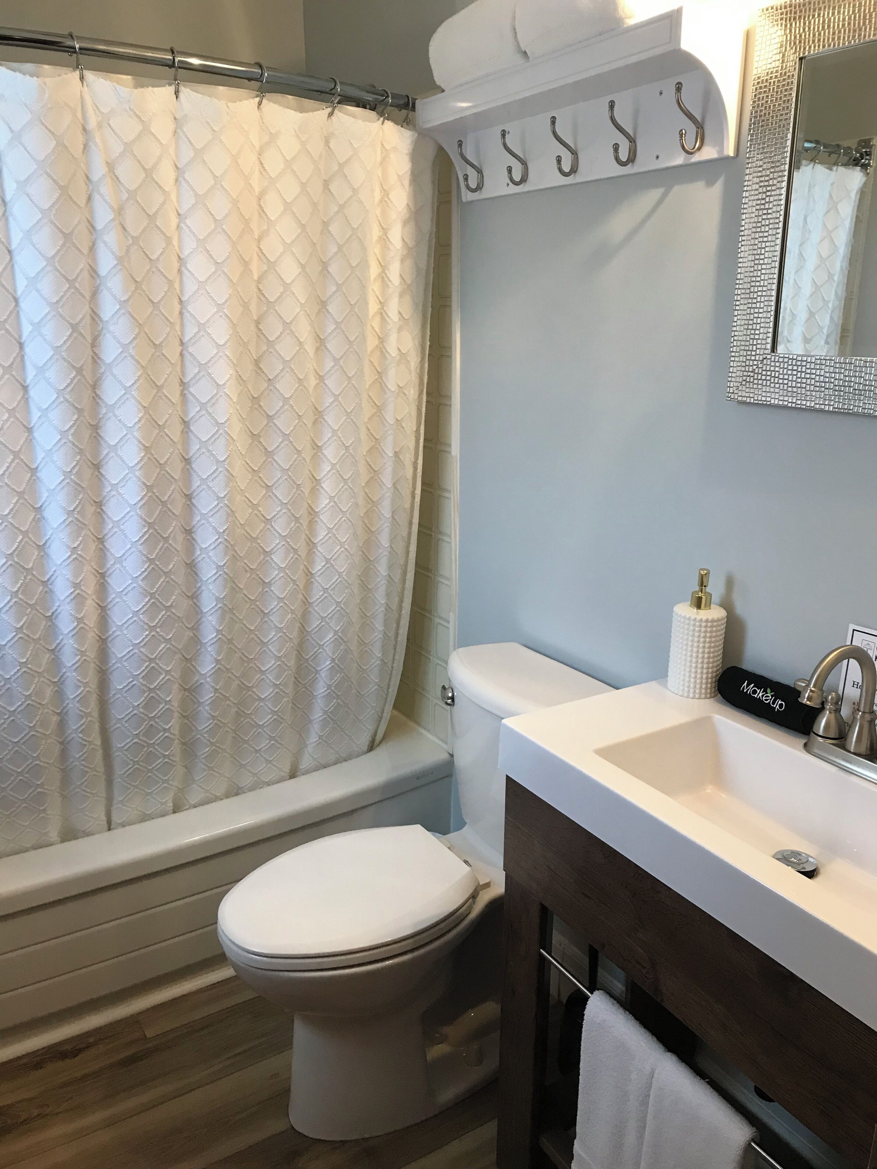 Un baño con inodoro, lavabo y cortina de ducha.