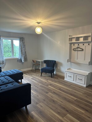 A room with a bed, a chair, a desk, and a dresser.