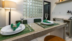 A dining area with a table set for two, a lamp, and a window with a view. - In front of the underground and 8 minutes from the beach | SF228 (Rio de Janeiro)