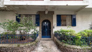A building with a stone facade, a blue door, and a cobblestone entrance.