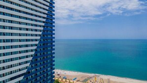 A high-rise building with a view of a beach and ocean.