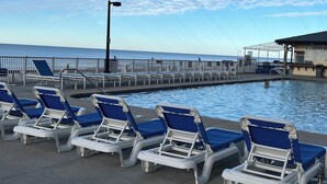 A poolside area with lounge chairs and a pier extending into the water. - 3 bedroom condo on the 12th floor in beautiful Panama City Beach (Panama City Beach)