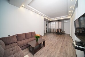Relax in this stylish living room with a comfortable sofa, flat-screen TV, and dining area.
