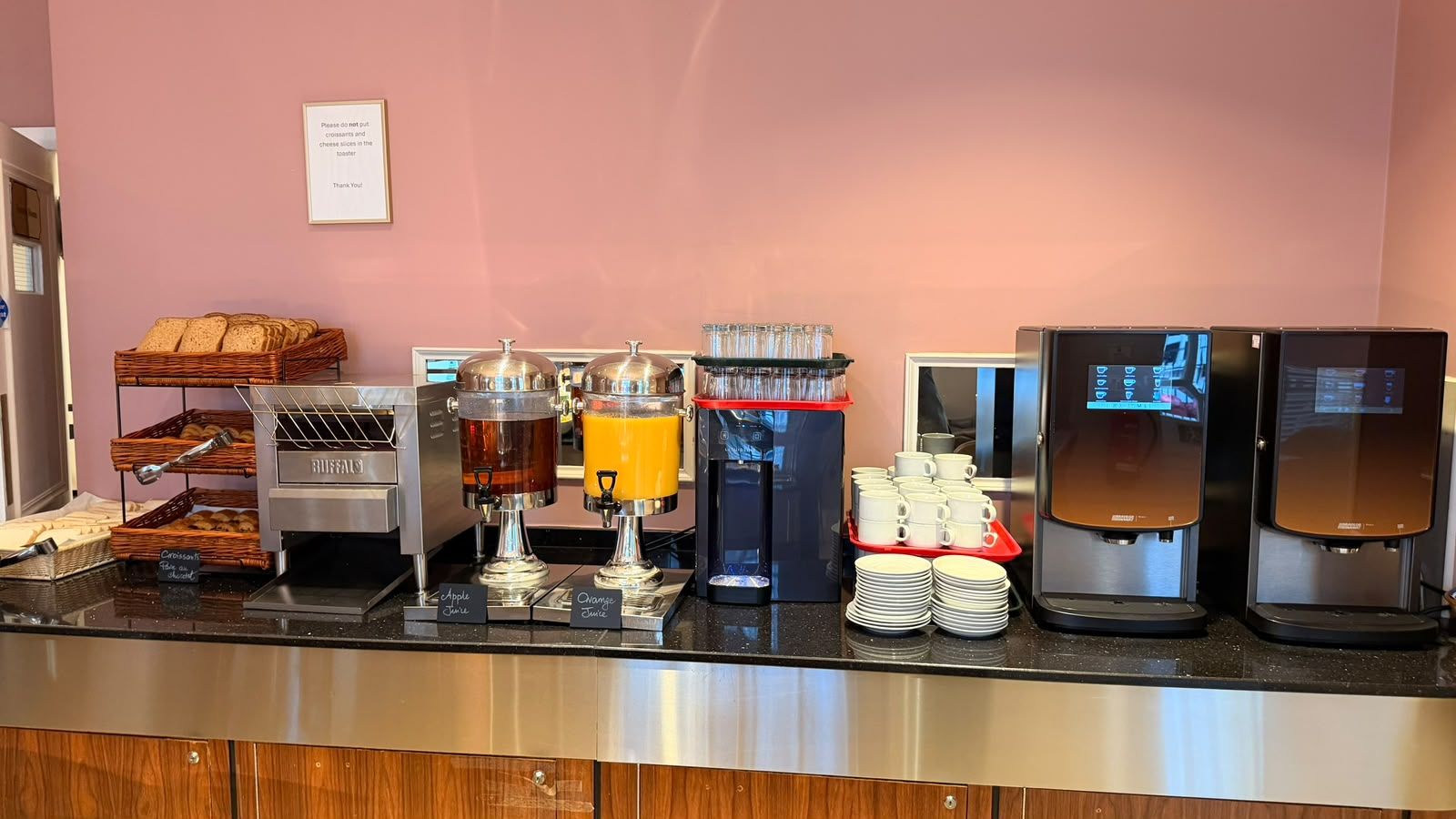 Un comptoir de buffet proposant une variété de plats et de boissons, notamment une machine à café et des distributeurs de jus.