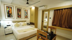 A hotel room with a bed, bedside tables, a chair, a desk, and a large mirror. - Wishotel Premier The Phoenix Hotel 2.O (Indore)