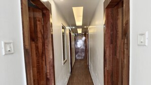 Un couloir étroit aux murs recouverts de lambris en bois et doté d’un plancher en bois.