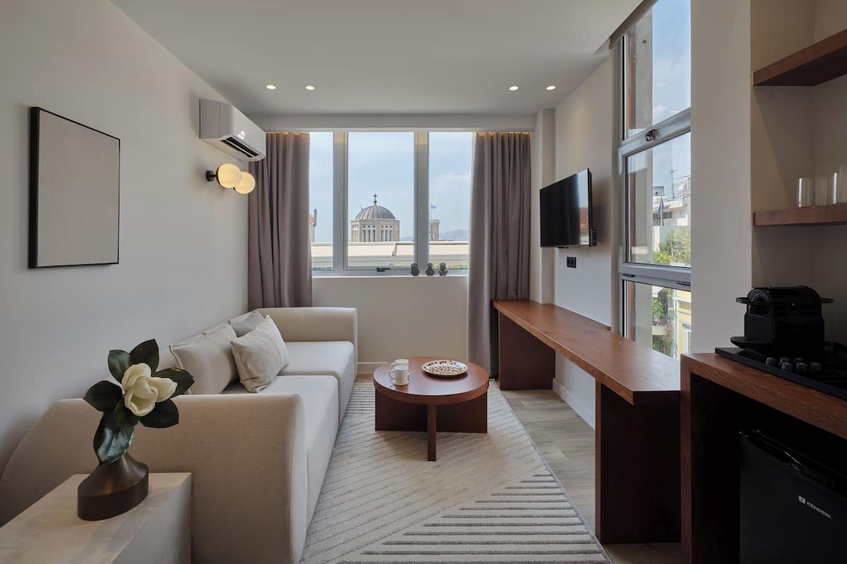 A modern living room with a sofa, a coffee table, and a TV mounted on the wall.
