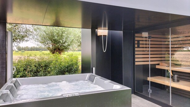 Ein modernes Badezimmer mit einer großen Badewanne, einer Duschkabine aus Glas und Blick auf einen Garten.