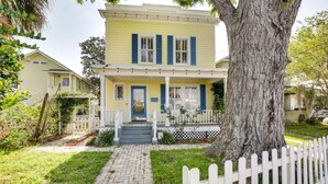 A two-story house with a front porch, a white picket fence, and a tree in the foreground. - Spacious Home Walk to Historic DT w/Yard, Bikes (Saint Augustine)