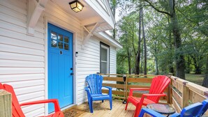 A wooden deck with blue and red Adirondack chairs, a small round table, and a blue door with a window. - zSALE! 2mi to Downtown & Front Street Attractions! (Wilmington)