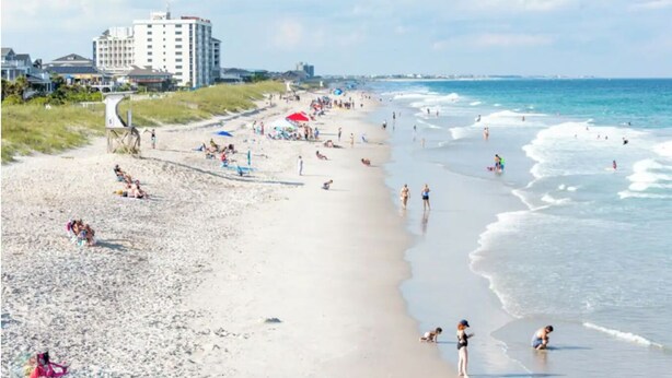 A beach with people, umbrellas, and a hotel in the background. - zSALE! 2mi to Downtown & Front Street Attractions! (Wilmington)