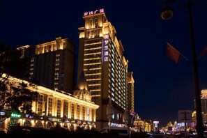 Un hotel de varios pisos con letreros iluminados y una entrada destacada.