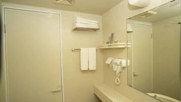 A bathroom with a shower, a sink, a mirror, a towel rack, and a hairdryer.