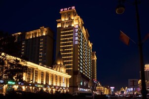 Un hotel de varios pisos con señalización iluminada, ventanas amplias y una entrada destacada.