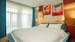 A hotel room with a large bed, a window with curtains, and two wall-mounted paintings. - Memo's Hotel (Manzhouli)