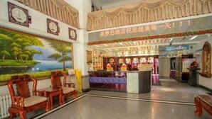A hotel lobby with ornate wooden chairs, a reception desk, and a mural of a landscape. - Memo's Hotel (Manzhouli)
