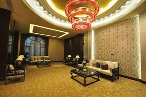 A hotel lobby with a circular chandelier, sofas, and a patterned carpet. - Green Bin Phoenix Hotel(Beiliu Country Garden ) (Beiliu)