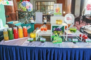 A buffet setup with various food and drink options, including a selection of juices and a fruit display. - Green Bin Phoenix Hotel(Beiliu Country Garden ) (Beiliu)