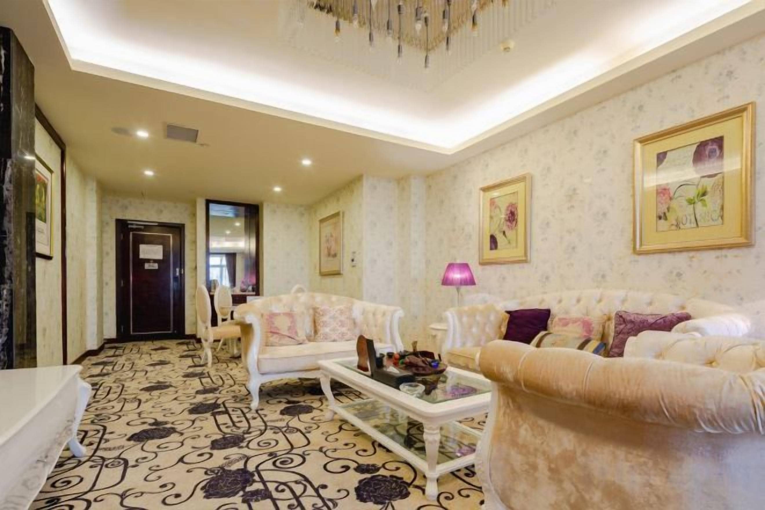 Amplia sala de estar con alfombra estampada, una mesa de centro blanca y dos sofás con cojines decorativos.