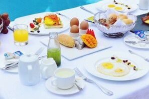 A breakfast setting with various dishes, including eggs, toast, and fruit, along with beverages and utensils. - Green Bin Phoenix Hotel(Beiliu Country Garden ) (Beiliu)