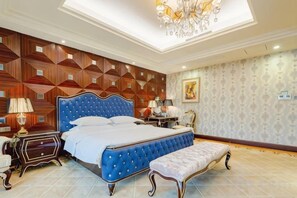 A bedroom with a large bed, a bench, a nightstand, and a chandelier. - Green Bin Phoenix Hotel(Beiliu Country Garden ) (Beiliu)