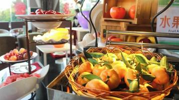 A buffet with various fruits and a fruit stand.