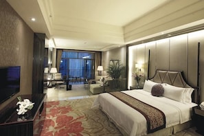 A hotel room with a large bed, a TV, a desk with a chair, and a view of the outside. - Green Bin Phoenix Hotel(Beiliu Country Garden ) (Beiliu)