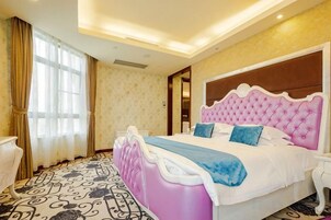 Quarto de hotel com uma cama grande, mesa de cabeceira e janela com cortinas.