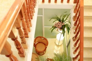 Una escalera de madera con una silla de mimbre y una planta en maceta.