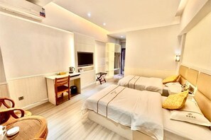 Una habitación de hotel con dos camas, un escritorio, una silla, un televisor y una mesita.