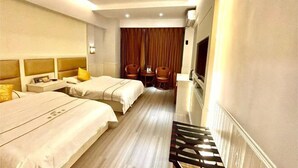 A hotel room with two beds, a desk, a chair, a TV, and a curtain. - Mangshi Cuidi Hotel (Mangshi)
