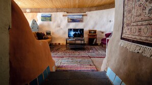 Un salon confortable avec un téléviseur, un canapé et un tapis.