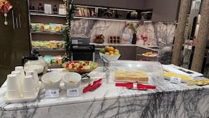 A buffet setup with various food items and utensils. - Charming City Hotel (Taipei)