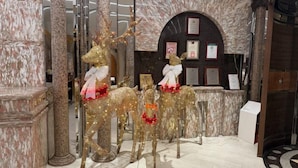 A lobby with marble columns, a reception desk, and decorative golden reindeer figures. - Charming City Hotel (Taipei)