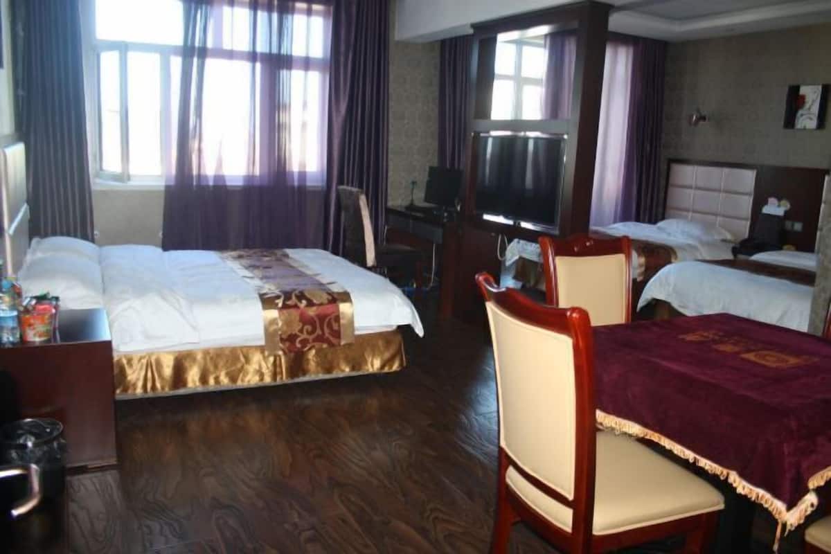Une chambre d’hôtel avec deux lits, une télévision, un bureau et une chaise.