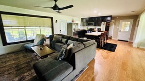 A living room with a gray sofa, a coffee table, and a ceiling fan. - Charming 4-bedroom house with AC and WiFi in peaceful Texarkana (Texarkana)