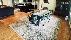 A spacious living room with a dining area, wooden flooring, a ceiling fan, and a kitchen in the background. - Charming 4-bedroom house with AC and WiFi in peaceful Texarkana (Texarkana)