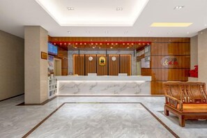 A hotel reception area with a marble reception desk, wooden paneling, and a traditional chair. - Super 8 Hotel (Sanming Sanyuan Chengguan Furong Road) (Sanming)